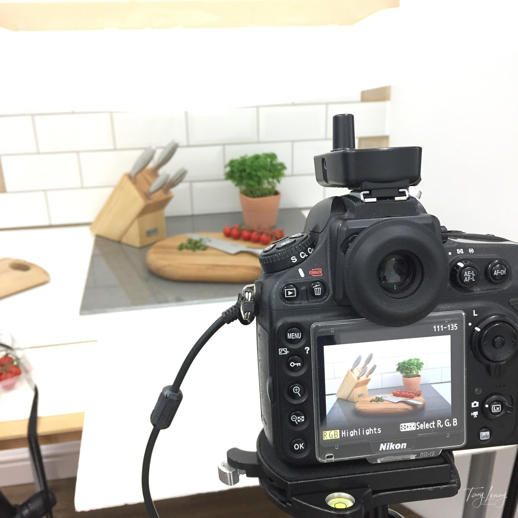 Close up of the back of the camera showing the scene being photographed with is a kitchen scene with the main product being kitchen knifes