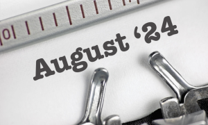 Close-up of the word 24 August typed on white paper with a typewriter, showing part of the typewriter’s metal typebars and ruler.