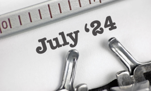 Close-up of typewriter keys and part of the typebar, with the text “24 July” typed in bold black font on white paper.