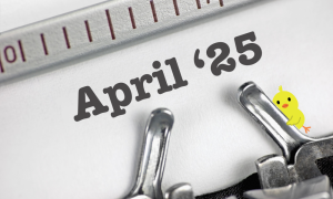 Close-up of typewriter keys with the text 25 April above them and a small cartoon yellow chick on the right side of the image.