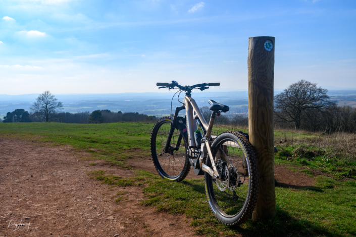 Mountain bike leaning against a post on top of Clent hills overlooking Blakedown and Malvern