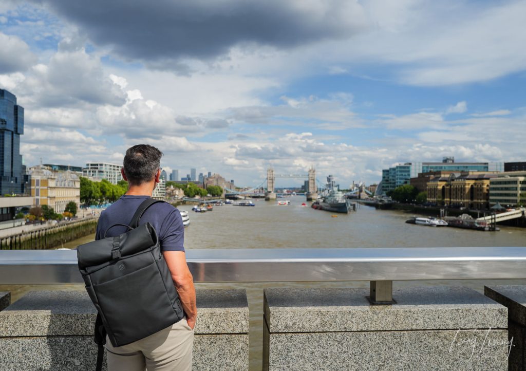A male model with a PW3R backpack looking over at Tower Bridge in London