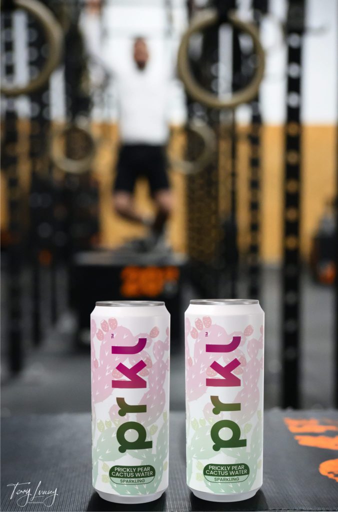 Man blurred out in background at gym with PRKL can in foreground for a product shot