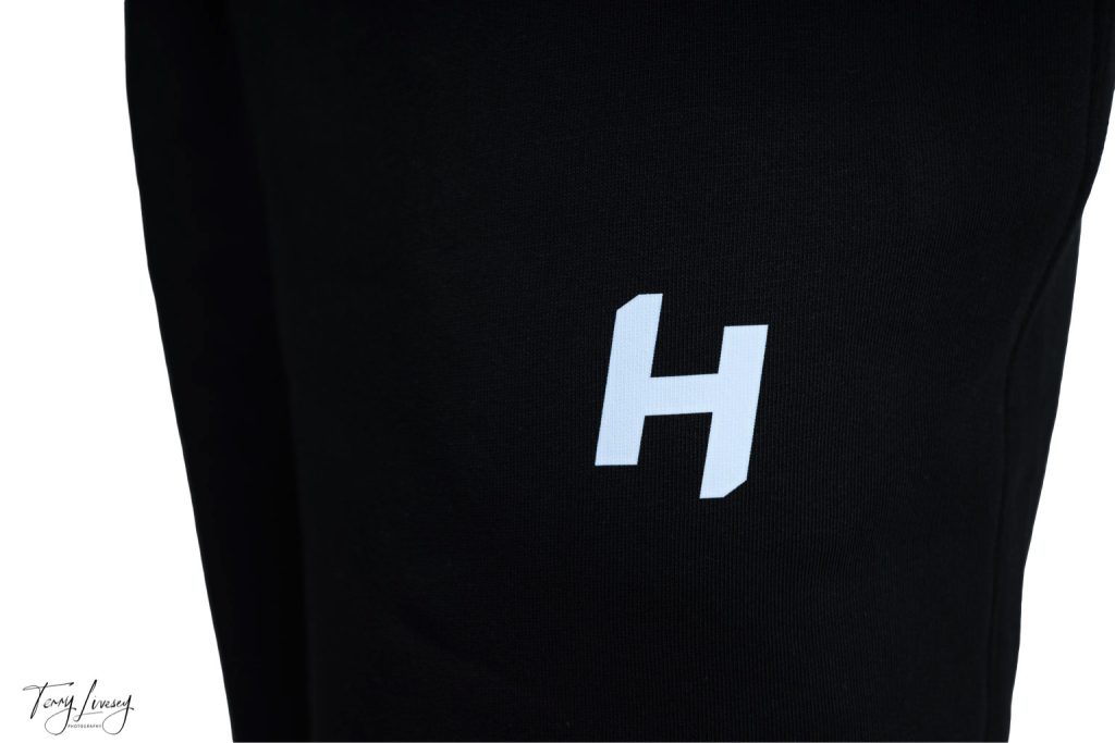 close up of H logo for Hybrid hub on shorts