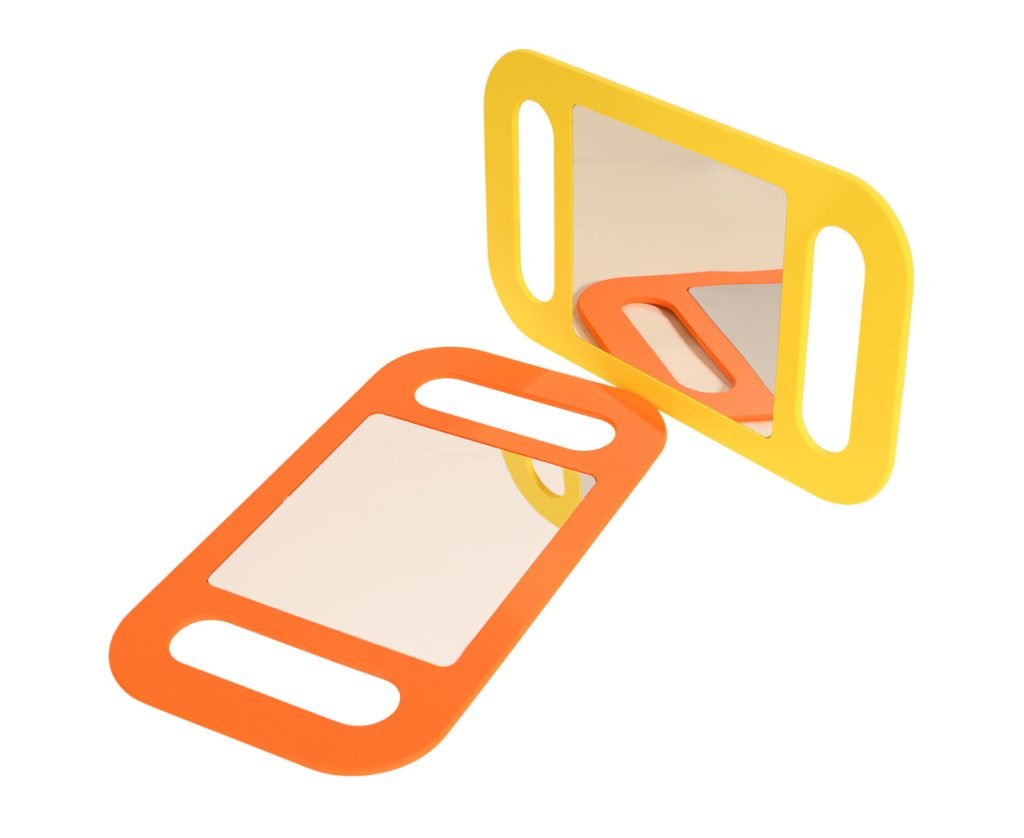 Two rectangular mirrors with rounded edges and handles, one with an orange frame lying flat and one with a yellow frame standing upright, both reflecting light.